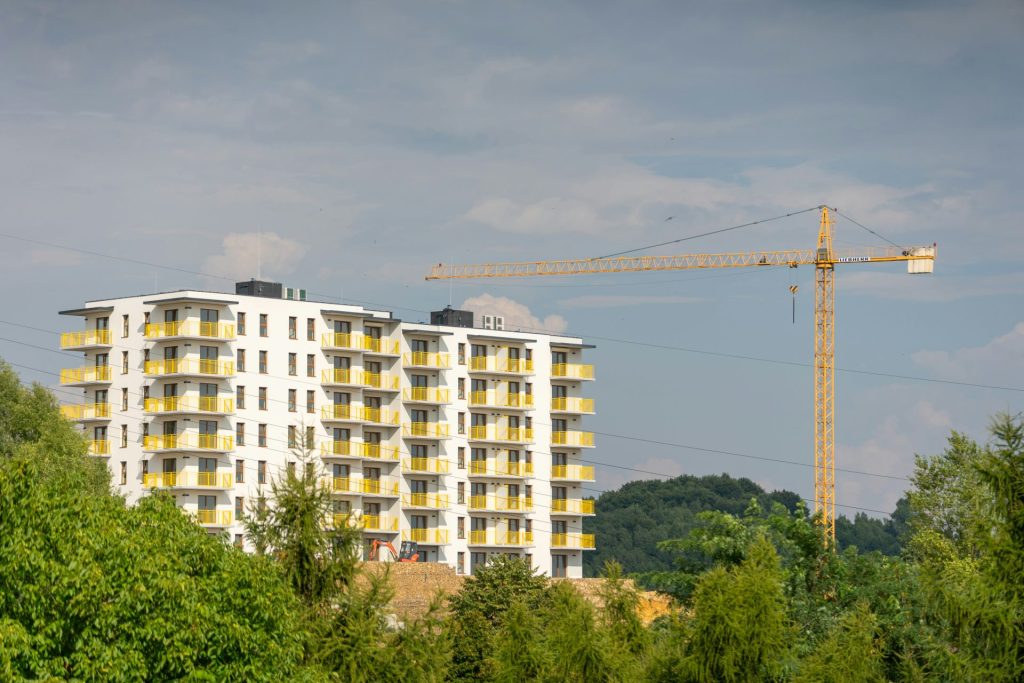 a tall white building with yellow balconies